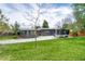 Single-story gray home features a red door, well-kept lawn, extended driveway, and mature landscaping at 450 Yukon St, Lakewood, CO 80226