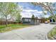 Modern home with a long driveway and neatly landscaped front yard, surrounded by mature trees at 450 Yukon St, Lakewood, CO 80226