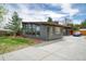 Modern gray home with a concrete driveway, large picture windows, and a well-maintained front yard at 450 Yukon St, Lakewood, CO 80226