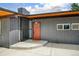Modern home exterior with a striking orange front door and a well-kept front porch at 450 Yukon St, Lakewood, CO 80226