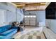 Finished garage space features a blue couch, wood ceiling, and a white and gray tiled floor at 450 Yukon St, Lakewood, CO 80226