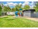 A backyard featuring a playground with a slide and climbing area, set among lush green grass at 450 Yukon St, Lakewood, CO 80226