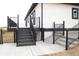 A multi-tiered back deck with black railings and white house in the background at 56315 E 74Th Ave, Strasburg, CO 80136