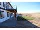 Landscaped backyard featuring a patio area and a graded hillside at 56315 E 74Th Ave, Strasburg, CO 80136