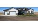 Charming home featuring a manicured lawn, stone accents, and an attached two-car garage at 56315 E 74Th Ave, Strasburg, CO 80136