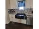 A kitchen sink with white cabinets, stainless steel appliances and fixtures, and tile backsplash at 56315 E 74Th Ave, Strasburg, CO 80136