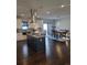 Open kitchen and dining area with modern appliances, a center island, and hardwood floors at 56315 E 74Th Ave, Strasburg, CO 80136
