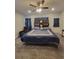 Main bedroom featuring a ceiling fan, large bed with a blue comforter, and plenty of space at 56315 E 74Th Ave, Strasburg, CO 80136