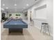 Open basement with plush carpeting, recessed lighting and a pool table with barstools at 5653 Yank St, Arvada, CO 80002