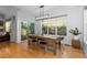 Bright dining room with a wooden table, modern lighting, and large windows showcasing the backyard at 5653 Yank St, Arvada, CO 80002