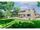 Spacious backyard with a well-manicured lawn, patio under a pergola, mature trees, and a shed at 531 Saber Creek Dr, Monument, CO 80132
