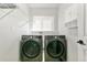 Functional laundry room features modern front loading machines, ample counter space, and overhead cabinets at 531 Saber Creek Dr, Monument, CO 80132
