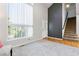 Bright living room featuring high ceilings, large window, hardwood floors, and adjacent carpeted staircase at 531 Saber Creek Dr, Monument, CO 80132