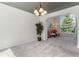 Open-concept living space with neutral carpet, gray ceiling, and views into the kitchen and front window at 531 Saber Creek Dr, Monument, CO 80132