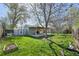 This backyard features a patio, lush green grass, and a tree in the background at 6819 Reno Dr, Arvada, CO 80002