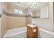 This bathroom features a shower over tub, vanity, and decorative tiling accents at 6819 Reno Dr, Arvada, CO 80002
