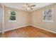 Sunny bedroom featuring hardwood floors and two bright windows at 6819 Reno Dr, Arvada, CO 80002