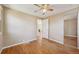 Bright bedroom featuring hardwood floors, a ceiling fan, and a mirrored closet at 6819 Reno Dr, Arvada, CO 80002