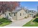 Side exterior showing a charming home with siding, an adjacent garage, and a paved driveway at 6819 Reno Dr, Arvada, CO 80002