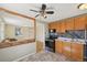 Cozy kitchen with wood cabinets, tile backsplash, and appliances, seamlessly connected to the living area at 6819 Reno Dr, Arvada, CO 80002