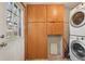 Laundry room featuring built-in wood cabinets and a stacked washer/dryer at 6819 Reno Dr, Arvada, CO 80002