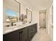 Modern bathroom showcasing a double vanity with black fixtures and a glass-enclosed shower at 6844 W 69Th Pl, Arvada, CO 80003