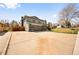 Gray two-story home with a gray garage door, a stone accent wall, and a large driveway at 6844 W 69Th Pl, Arvada, CO 80003