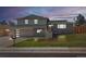 Charming home with stone facade, lush lawn, and inviting front entrance at dusk at 6844 W 69Th Pl, Arvada, CO 80003