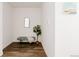 Bright hallway with hardwood floors, a decorative bench, a modern mirror, and clean white walls, offering a stylish entry at 1898 S Bannock St # 510, Denver, CO 80223