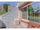Balcony view featuring a large window, brick trim, exterior storage, and wood decking at 3951 S Carson St # D, Aurora, CO 80014