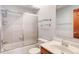 Bathroom featuring a shower and bath, glass shower door, white vanity and toilet at 3951 S Carson St # D, Aurora, CO 80014
