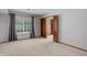 Empty bedroom with plush carpet, large window, and closet with built in shelves at 3951 S Carson St # D, Aurora, CO 80014
