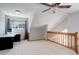 Angled bedroom with carpet, ceiling fan, desk near window, and wooden railing at 3951 S Carson St # D, Aurora, CO 80014