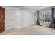 Inviting bedroom featuring neutral carpet, white shiplap walls, and a large window at 3951 S Carson St # D, Aurora, CO 80014