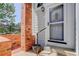 Charming front entrance featuring brick accents, glass storm door and concrete steps at 3951 S Carson St # D, Aurora, CO 80014