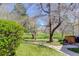 Manicured greenspace view beside building with sidewalk and mature trees casting shadows at 3951 S Carson St # D, Aurora, CO 80014