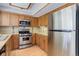Kitchen featuring stainless steel appliances, wooden cabinets, and granite countertops at 3951 S Carson St # D, Aurora, CO 80014