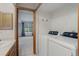 This laundry room offers a washer, dryer, and a view into an adjacent bedroom at 3951 S Carson St # D, Aurora, CO 80014