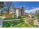 Charming exterior view of townhome with a brick chimney, green lawn, and well-maintained landscaping at 7077 S Knolls Way, Centennial, CO 80122