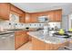 Modern kitchen featuring granite countertops, stainless steel appliances, and warm wood cabinetry at 7077 S Knolls Way, Centennial, CO 80122