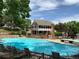 Expansive community pool with lounge chairs, set against a backdrop of beautiful homes and trees at 7077 S Knolls Way, Centennial, CO 80122