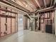 Unfinished basement area with exposed ceiling, utility infrastructure, and a doorway to another room at 10000 E Yale Ave # 58, Denver, CO 80231