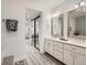 A modern bathroom with double sinks, white cabinets, and stylish mirrors at 10000 E Yale Ave # 58, Denver, CO 80231
