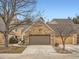 A two-car garage with a stone facade and a paved driveway in front of the home at 10000 E Yale Ave # 58, Denver, CO 80231