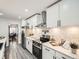 A modern kitchen featuring stainless steel appliances, white cabinets, subway tile backsplashes and sleek gray flooring at 10000 E Yale Ave # 58, Denver, CO 80231