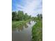 Scenic view of the stream surrounded by lush greenery and blue skies at 10000 E Yale Ave # 58, Denver, CO 80231