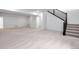 Open, unfinished basement featuring neutral colored carpet and staircase with black railing at 24741 E 33Rd Dr, Aurora, CO 80019