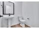 Modern bathroom featuring white sink and toilet with wood floor at 24741 E 33Rd Dr, Aurora, CO 80019