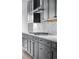 Modern kitchen featuring gray cabinets, white backsplash, and stainless steel appliances at 24741 E 33Rd Dr, Aurora, CO 80019