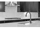 Close-up of a kitchen sink with modern faucet and herringbone tile backsplash at 24741 E 33Rd Dr, Aurora, CO 80019